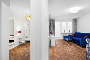 a living room with a blue couch and a bedroom at Apartament Warszawa STARE MIASTO in Warsaw