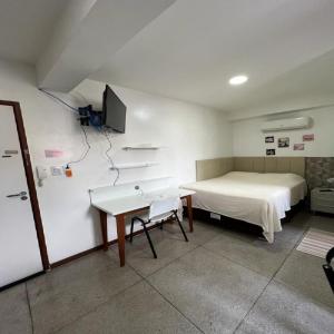 ベレンにあるSTUDIO 305 | WIFI 600MB | RESIDENCIAL JC, um lugar para ficar.のベッド、テーブル、テレビが備わる客室です。