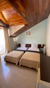 2 Betten in einem Schlafzimmer mit Holzdecke in der Unterkunft Bela Sombra in Vila da Ribeira Brava