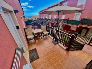 a balcony with an umbrella and a table and chairs at Casilla Bubo in Costa de Antigua
