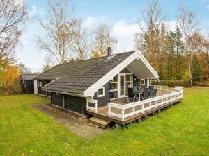 a small house with a large deck in a field at 10 person holiday home in F rvang in Fårvang