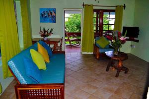 un soggiorno con divano e tavolo di The Still Beach Resort-Room 5 a Soufriere