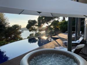 bañera de hidromasaje en una terraza con sombrilla en Blueview Villa, en Llafranc