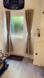 a room with a door with a window and curtains at Stay in Woking with Chidi in Horsell