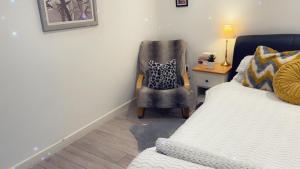 a bedroom with a bed and a chair next to a desk at Stay in Woking with Chidi in Horsell