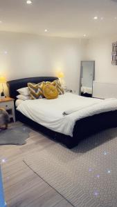 a bedroom with a large bed with yellow pillows at Stay in Woking with Chidi in Horsell