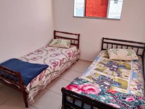 two beds sitting next to each other in a room at Apartamento Padrão 2° Andar in Vespasiano