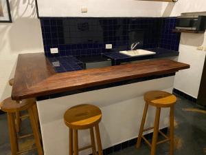 - un comptoir de cuisine avec deux tabourets et un évier dans l'établissement Posada 1885, à Santiago