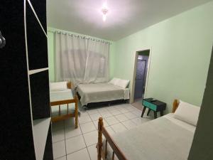 a small room with two beds and a window at Pousada355 in Passo Fundo