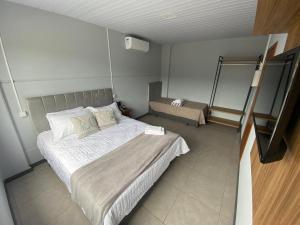 Dormitorio pequeño con cama y espejo en Morada Pomerode, en Pomerode