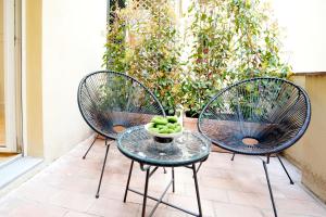 2 Stühle und ein Glastisch mit einer Obstschale in der Unterkunft Luxury apartment - KUKI STAY Ponte Vecchio in Florenz