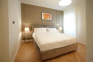 una camera da letto con un grande letto bianco e una finestra di Luxury apartment - KUKI STAY Ponte Vecchio a Firenze