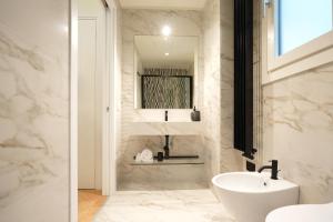 bagno bianco con lavandino e specchio di Luxury apartment - KUKI STAY Ponte Vecchio a Firenze