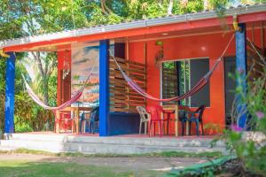 ein Haus mit Stühlen und einem Tisch davor in der Unterkunft Cabañas Los Venaos in San Bernardo del Viento