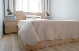 um quarto com uma cama com um cobertor branco em Apartament Widok Cieplice em Jelenia Góra