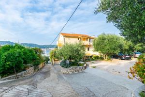 a house on a hill with trees and a street at Apartments Sabina in Supetarska Draga