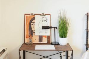 biurko z lampką, obrazem i rośliną w obiekcie Classic & Cozy Apartments - Parking & Close To Dw w mieście Medford
