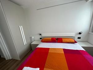 a bedroom with a colorful blanket on a bed at Penelope Home by Casa e Lode in Passo del Tonale
