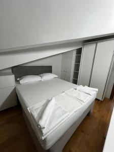 a white bed in a room with a window at Primo Classe apartment 1 in Skopje