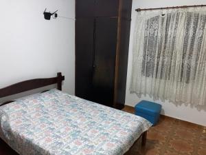 a bedroom with a bed and a window at Apartamentos Petrópolis in Ubatuba