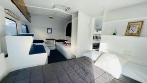 a small bedroom with a bed and a couch at Orere Point Top 10 Holiday Park in Auckland