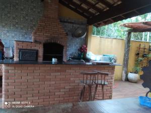 eine Außenküche mit einem Steinofen in der Unterkunft Casa do Patrão in Ilha Comprida