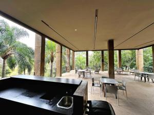 グアダラハラにあるHomely Escape in Providencia.のテーブルと椅子、大きなプールが備わる広い客室です。