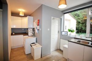a kitchen with white cabinets and a large window at Stunning Spacious One Bedroom Haven in Wyken