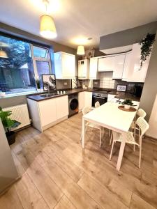 uma cozinha com uma mesa branca e cadeiras em Stunning Spacious One Bedroom Haven em Wyken