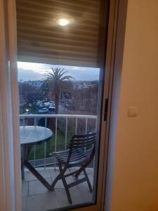 a window with a table and a chair on a balcony at Azoresaccommodation in Lagoa