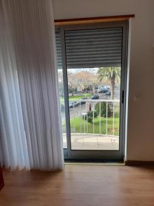 a sliding glass door with a view of a parking lot at Azoresaccommodation in Lagoa