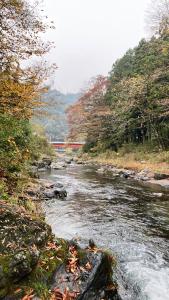 a river with rocks and a train in the background at 川辺-KAWABE-BBQ-川遊び-fishing in Hanno