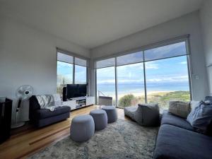 a living room with a couch and a large window at Three Little Birds at Freycinet in Coles Bay +27 photos