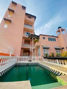 a building with a swimming pool in front of a building at Hotel Boutique Rivera Del Rio in Puerto Vallarta