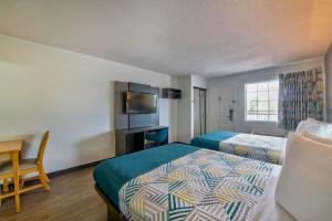 a hotel room with two beds and a desk at Studio 6-Pascagoula, MS in Pascagoula