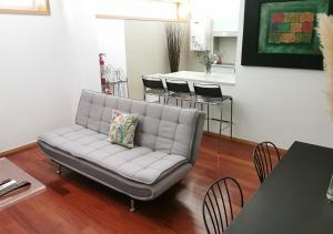 um sofá numa sala de estar com uma mesa e cadeiras em Loft station em Guimarães