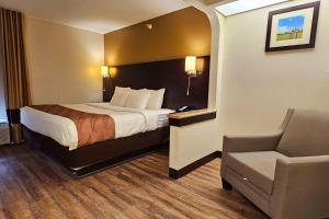 a hotel room with a bed and a chair at Quality Inn & Suites near St Louis and I-255 in Cahokia