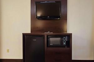 um micro-ondas e uma televisão na parede em Quality Inn & Suites near St Louis and I-255 em Cahokia