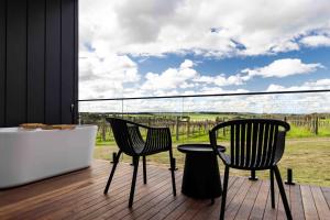 twee stoelen en een tafel op een terras met uitzicht bij Mt Duneed Estate in Mount Duneed