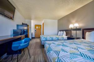 a hotel room with two beds and a television at Motel 6 Stuart, Ia in Stuart