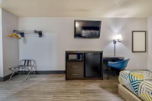 Cette chambre comprend un lit, un bureau et une télévision. dans l'établissement Motel 6 Stuart, Ia, à Stuart