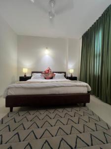 una camera da letto con un grande letto con tende verdi di Panorama Haven With Swimming Pool a Lucknow