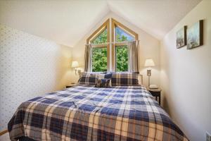 a bedroom with a bed with a plaid blanket and a window at Highridge J5B Spectacular 1 Bedroom Escape with fireplace, sauna & resort amenities in Killington +13 photos