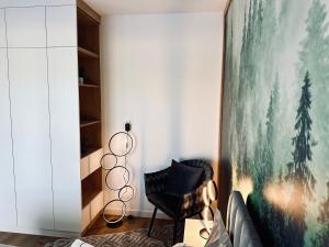 a living room with a couch and a large painting at Mountain Shine - Apartment, SPA and Parking in Zakopane