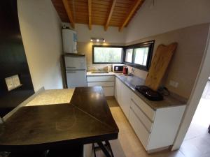 a small kitchen with white cabinets and a counter top at Cabaña en Barrio Privado de Potrerillos in Potrerillos