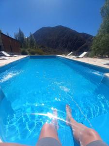 a person laying on the side of a swimming pool at Cabaña en Barrio Privado de Potrerillos in Potrerillos