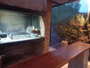 een houten bank voor een stenen open haard bij Cabaña en Barrio Privado de Potrerillos in Potrerillos +29 foto's