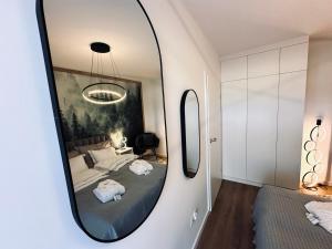 ein Schlafzimmer mit einem Spiegel an der Wand in der Unterkunft Mountain Shine - Apartment, SPA and Parking in Zakopane