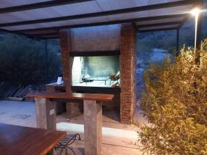 a stone pizza oven on a patio with a table at Cabaña en Barrio Privado de Potrerillos in Potrerillos