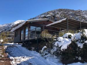 een huis aan de kant van een met sneeuw bedekte berg bij Cabaña en Barrio Privado de Potrerillos in Potrerillos